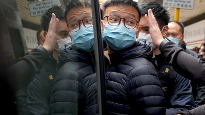 El editor de Stand News Patrick Lam, escoltado por agentes de policía a una furgoneta, 29/12/2021, Hong Kong, China