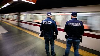 Policemen wait on a platform to check the green health pass of public transportation passengers in Rome, Monday, Dec. 6, 2021.