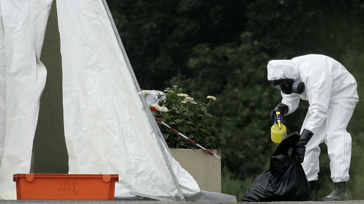 A veterinary worker, sprays a bag with disinfectant at a large poultry farm where an outbreak of the H5N1 birdflu virus was reported in Kosorin, Czech Republic, July 12, 2007.