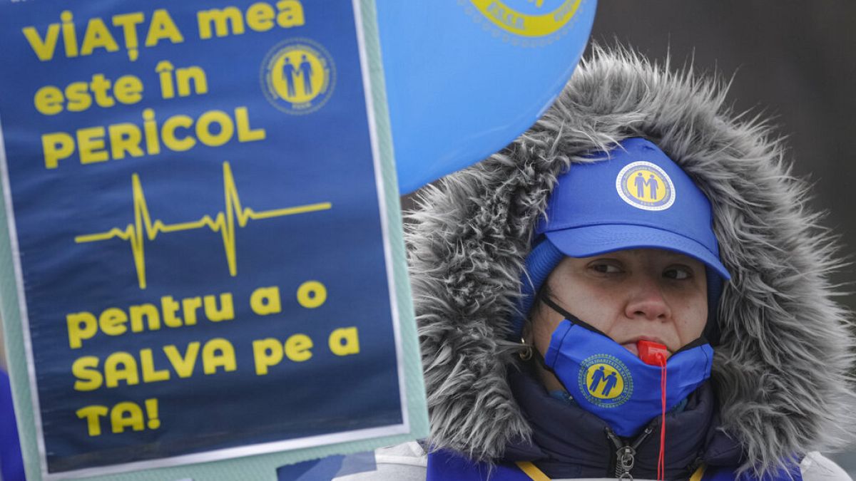 "Veszélyben van az életem, hogy megmentsem a tiédet" - áll egy román egészségügyi dolgozó tábláján. Kórházi dolgozók tüntettek Bukaresten kedden bérnövelést követelve.