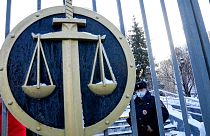 A police officer guards a an entrance of the Moscow Court where supporters of the Memorial human rights group gather in Moscow, Russia, Wednesday, Dec. 29, 2021.