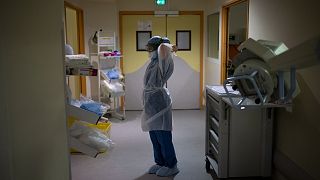 A radiographer prepares to enter the room of a COVID-19 patient in the continued care unit at the Timone hospital in Marseille, France, Dec. 24, 2021.