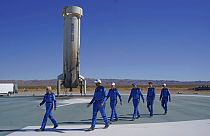 11 dicembre 2021: passeggeri spaziali di Blue Origin camminano sulla piattaforma di atterraggio del booster