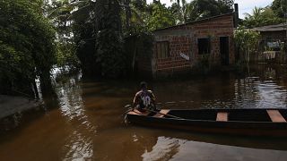 Lucas Ancelmo navega hacia su casa en las aguas de la inundación en Vila Juerana, una zona rural de Ilheus, estado de Bahía, Brasil, miércoles, 29 de diciembre de 2021