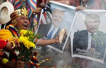 Shamans hold photos of Joe Biden & Vladimir Putin during a year-end ritual where they predict political & social issues expected to occur in 2022 in Lima, Peru, Dec. 29, 2021.
