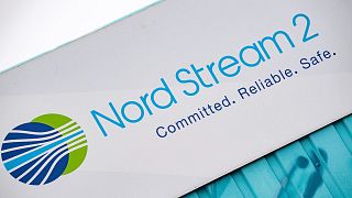 A sign reading "Nord Stream 2 Committed. Reliable. Safe." hangs above a painted map at the natural gas receiving station in Lubmin, Germany, on Nov. 16, 2021.