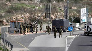 جنود إسرائيليون يتجمعون في موقع محاولة الطعن عند مفترق طرق بالقرب من مستوطنة جيتي أفيشار في الضفة الغربية.