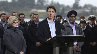 رئيس وزراء كندا جاستن ترودو وإلى يساره وزيرة العمل كارلا كوالتروف