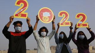 لافتة التهاني بالعام الجديد في الهند حث على ارتداء الكمامات والتطعيم للمساعدة في الحد من انتشار الفيروس التاجي.