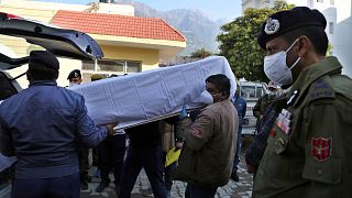 Health workers carry the coffin of a victim, who died in a stampede at the Mata Vaishnav Devi shrine, at a hospital in Katra, India, Jan. 1, 2022.