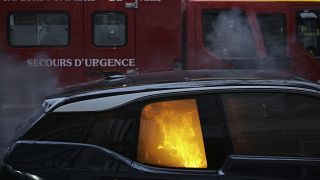 A firefighters truck parks by a burning car during a demonstration, Dec. 5, 2020 in Paris.