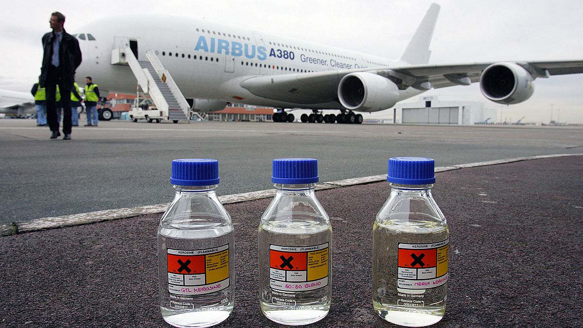 زجاجة واحدة تحتوي على كيروسين وزجاجتان تحتويان على جي تي إل ، وقود سائل "أخضر" مصنوع من الغاز الطبيعي أمام طائرة إيرباص. 2008/02/01