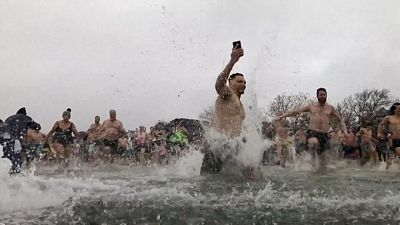 A large group of people running into water