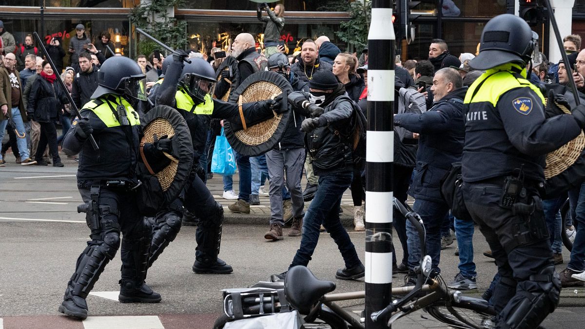 Police clash with demonstrators as thousands of people defied a ban to gather and protest the Dutch government's coronavirus lockdown measures, in Amsterdam, Jan. 2, 2022.