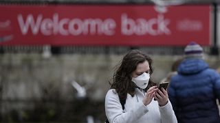 Женщина в маске на Трафальгарской площади в Лондоне
