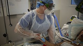 In einem Krankenhaus in Marseille hält eine Krankenschwester einem Covid-Intensivpatienten die Hand