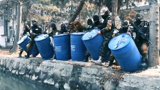 Las fuerzas especiales de Afganistán disponiéndose a tirar el alcohol a un canal de Kabul