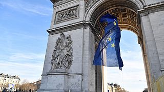 Bandeira da União Europeia sob o Arco do Triunfo, em Paris, França