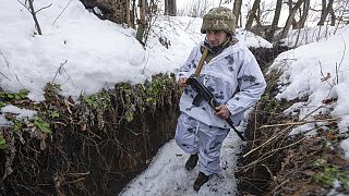 Un soldat ukrainien marche sur la ligne de séparation des rebelles pro-russes, région de Donetsk, Ukraine, dimanche 2 janvier 2022.
