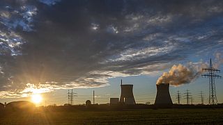 Steam rises from the cooling tower of the nuclear power plant of Gundremmingen, Bavaria, Germany, Friday, Dec. 31, 2021. 