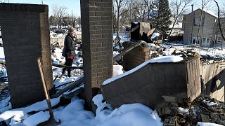 Rex Hickman, foreground, sifts through the rubble of his burned home with the help of his son Austin Hickman, in Louisville, Colo., on Sunday, Jan. 2, 2022.
