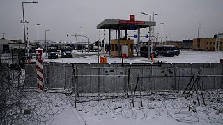 The "Kuznitsa" checkpoint is pictured behind barbed wire fence at the Belarus-Poland border.