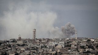 In this Thursday, Sept. 19, 2013 photo, smoke rises after a bomb was thrown from a helicopter, hitting a rebel position during heavy fighting in Idlib province, Syria.