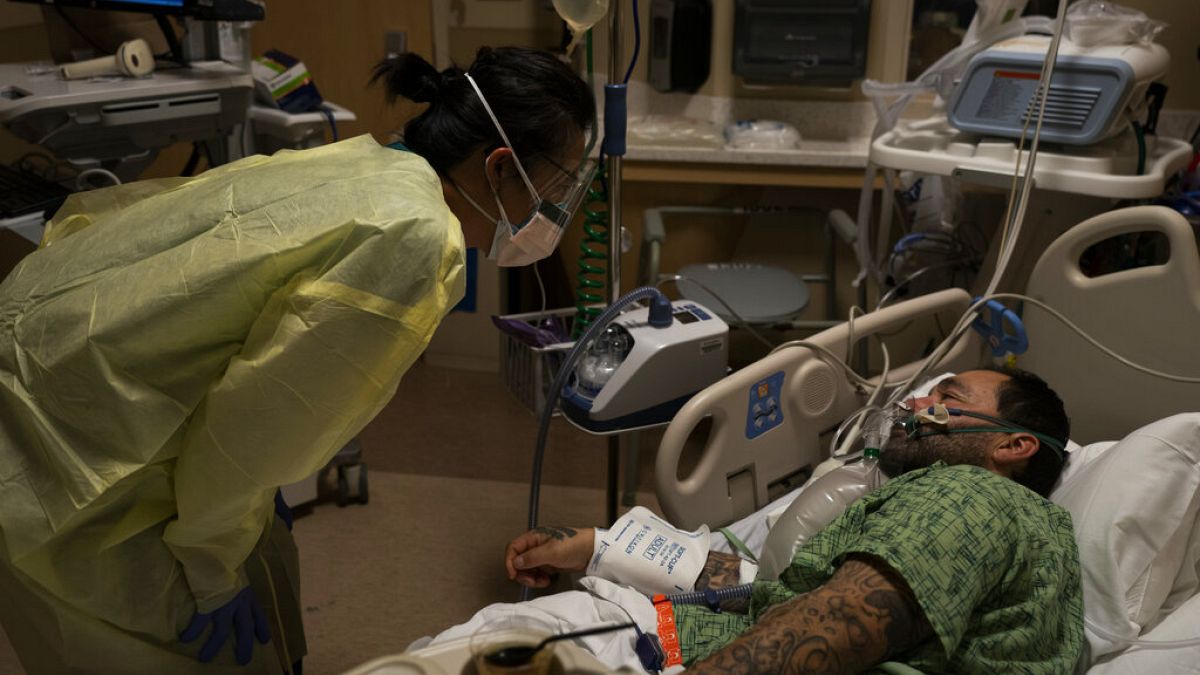 La enfermera registrada Emily Yu, a la izquierda, habla con Paul Altamirano, un paciente de 50 años de COVID-19