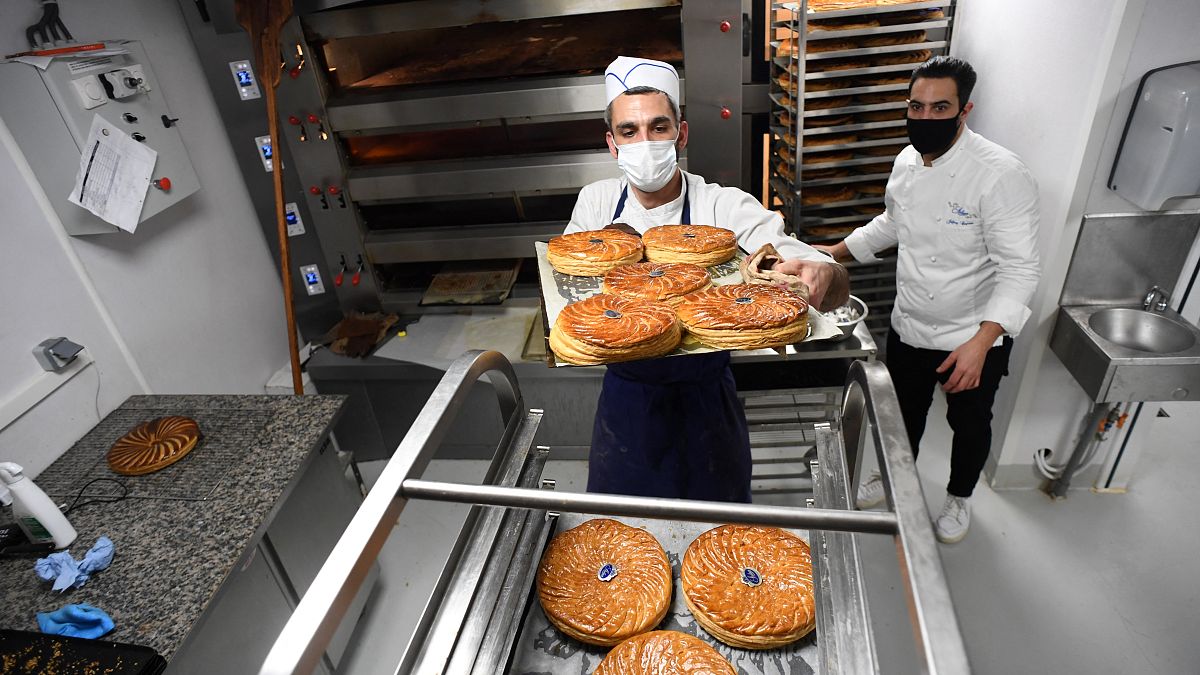 Konditor Jeffrey Cagnes und ein Bäcker nehmen in der Konditorei Stohrer, der ältesten in Paris, den traditionellen Dreikönigskuchen aus dem Ofen.