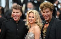 Igor Bogdanoff (R) and his partner Julie (C) and twin-brother Grichka Bogdanoff (L) arrive at the 71st edition of the Cannes Film Festival on May 15, 2018.