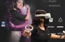 A CES attendee demonstrates the Owo vest, which allows users to feel physical sensations during metaverse experiences such as virtual reality games