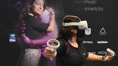 A CES attendee demonstrates the Owo vest, which allows users to feel physical sensations during metaverse experiences such as virtual reality games
