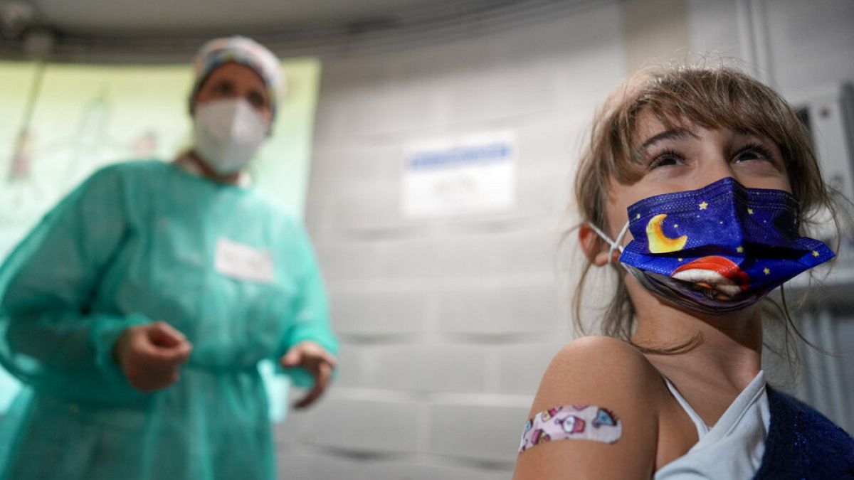 Kislány mutatja sebtapaszát, miután beoltották a Pfizer 11 év alatti gyerekeknek szánt vakcinájával Rómában, 2021. december 15-én