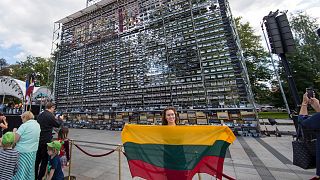 A litván függetlenség ünnepe 2019-ben; a háttérben 1500 régi rádióból összeállított fal: a készülékekkel koordinálták az ún. balti emberi láncot