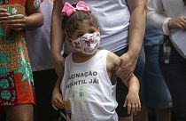 "Vacinação Infantil, Já!", lê-se numa blusa envergada por criança durante a manifestação pelas vacinas contra a covid-19