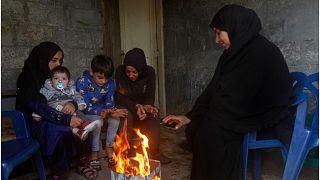 عائلة سورية تستخدم النار لتدفئة في قرية الصرفند بالقرب من مدينة صيدا اللبنانية