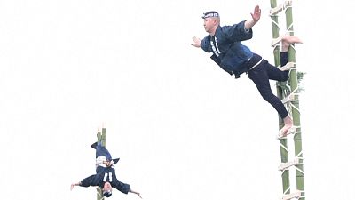Tokyo firemen perform traditional firefighting acrobatics at New Year drills