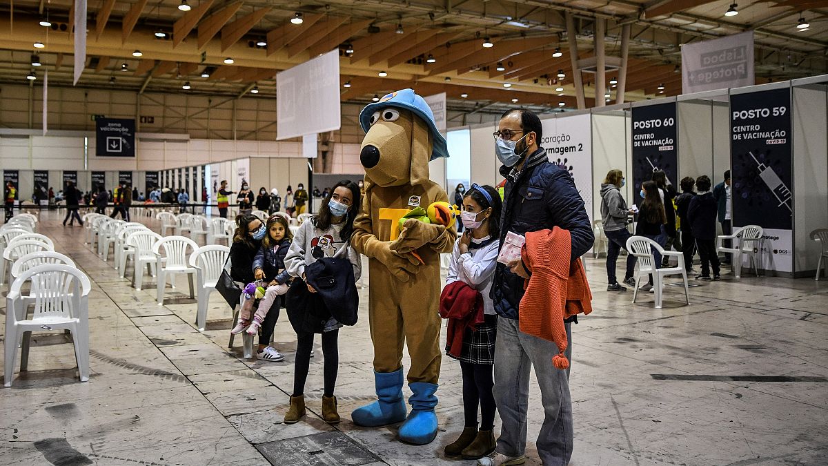 Kinder posieren für ein Foto mit dem "Impf-Maskottchen" in einem Impfzentrum in Lissabon (Dezember 2021) 