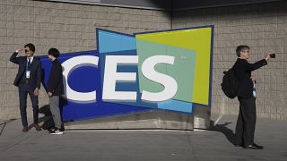People take pictures in front of a sign during the CES tech show Thursday, Jan. 6, 2022, in Las Vegas.