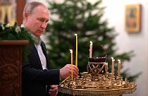 الرئيس الروسي فلاديمير بوتين يضيء شمعة خلال قداس عيد الميلاد الأرثوذكسي في كنيسة صورة المنقذ في نوفو أوغاريوفو خارج موسكو.