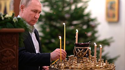 الرئيس الروسي فلاديمير بوتين يضيء شمعة خلال قداس عيد الميلاد الأرثوذكسي في كنيسة صورة المنقذ في نوفو أوغاريوفو خارج موسكو.