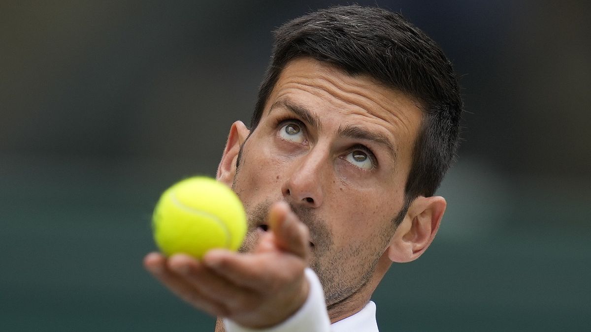 Serbia's Novak Djokovic serves to Hungary's Marton Fucsovics during the men's singles quarterfinals match on day nine of the Wimbledon Tennis Championships in London