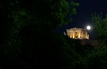 The full moon rises over ancient Parthenon temple in central Athens, Wednesday, Jan.19, 2011