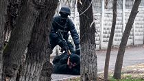 Ein Demonstrant in Almaty wird von einem Polizisten gestellt