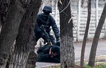 Ein Demonstrant in Almaty wird von einem Polizisten gestellt