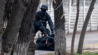 Um polícia de choque detém um manifestante em Almaty, Cazaquistão