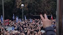 Protesters gathered outside party headquarters (before police intervention), holding up v-sign fingers, shouting (Albanian) "Oh Sali, oh hero, all of Albania loves you."