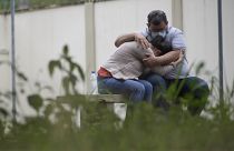 A couple embraces as they wait for information about missing relatives after a massive slab of rock toppled onto pleasure boaters at Furnas reservoir on Saturday
