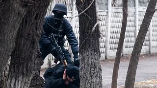 Egy terrorelhárítási rendőr őrizetbe vesz egy tüntetőt Almatiban, 2022. január 8-án