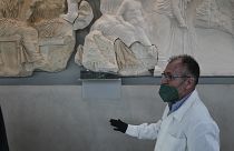 A conservator stands next to a Parthenon fragment, on loan from the Antonino Salinas Regional Archaeological Museum of Palermo, at the Acropolis Museum in Athens